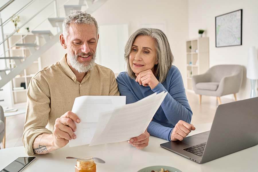 An older couple work out how much to transfer to their savings certificate each month.